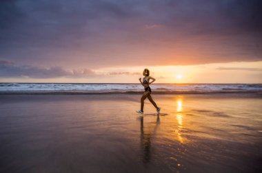 Silhouette uyum ve atletik Asyalı Çinli sportif kadın fitness sağlıklı yaşam tarzı ve yaz açık havada etkinlik kavramı Sunset'teki koşu egzersiz yapıyor güzel plaj üzerinde çalışan