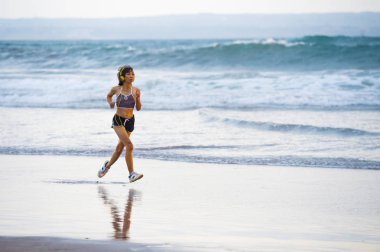 uyum ve atletik Asyalı Çinli sportif kadın fitness sağlıklı yaşam tarzı ve yaz açık havada etkinlik kavramı Sunset'teki koşu egzersiz yapıyor güzel plaj üzerinde çalışan