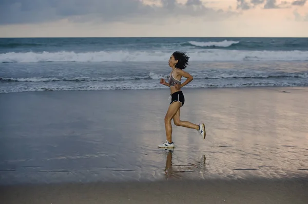 フィット感とフィットネスの健康的なライフ スタイルや夏のアウトドア活動の概念の夕日にジョギングのトレーニングをして美しいビーチを走る競技アジア中国スポーティな女性 — ストック写真