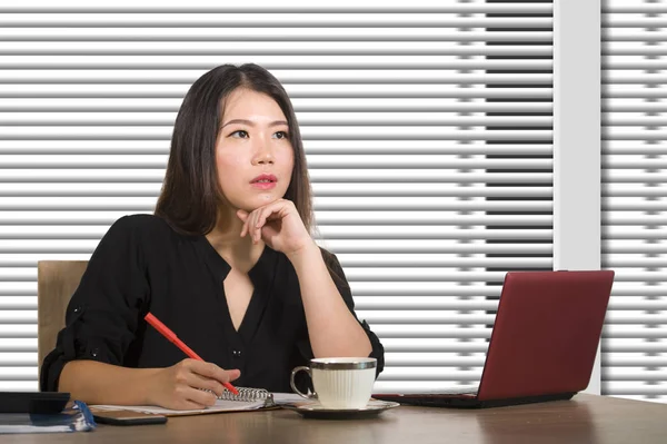 company corporate portrait of young beautiful and busy Asian Korean woman working busy at modern office computer desk by venetian blinds window in business lifestyle and executive job concept