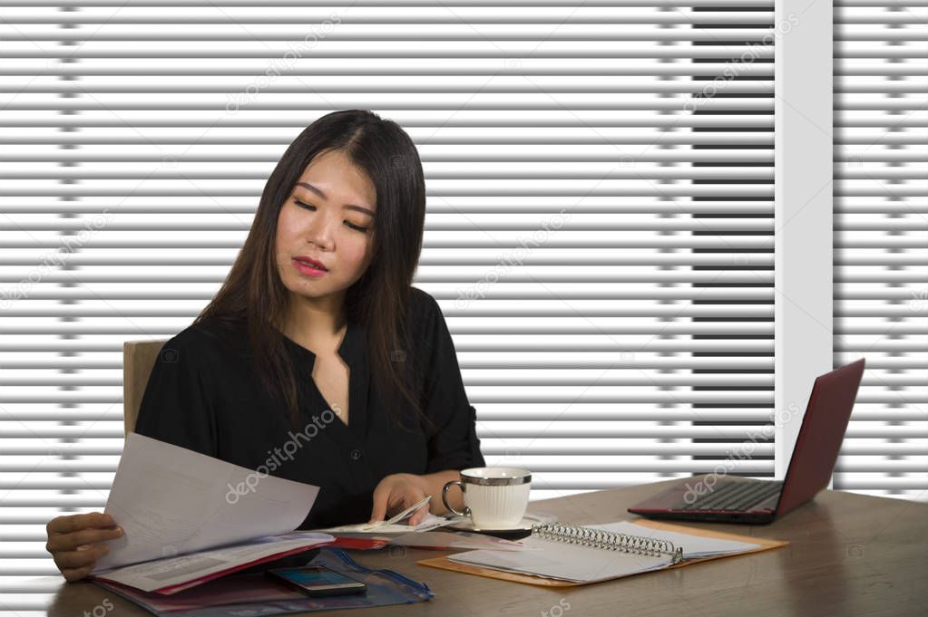 company corporate portrait of young beautiful and busy Asian Chinese woman working busy at modern office computer desk by venetian blinds window in business lifestyle and executive job concept 