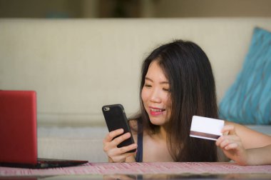Bankacılık ve Finans başarı ve elektronik iş kavramı gülümseyen alışveriş online internet için cep telefonu kullanarak kredi kartı tutan genç mutlu ve güzel Asyalı Koreli kadın