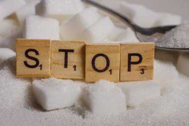 kavramsal natürmort beyaz yığını ile şeker küpleriyle ve Word'ün blok bağımlılığı kalori fazla tavsiye olarak harflerle durdurma ve sağlıksız yiyecek kötüye neden olan sağlık sorunu ve fazla kilolu 