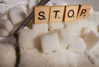 kavramsal natürmort beyaz yığını ile şeker küpleriyle ve Word'ün blok bağımlılığı kalori fazla tavsiye olarak harflerle durdurma ve sağlıksız yiyecek kötüye neden olan sağlık sorunu ve fazla kilolu 