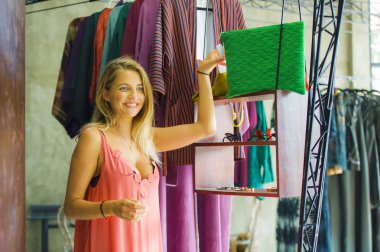 Genç güzel ve mutlu sarışın kadın vintage ve serin güzellik moda giysiler denemek alışveriş zevk depolamak neşeli eğlence gülümseyen alış satış ve fırsat giyim