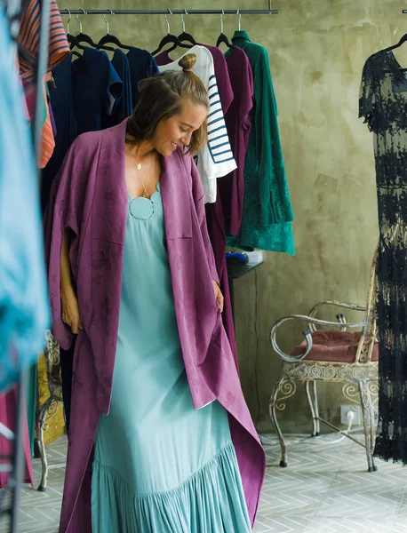 Genç güzel ve aynaya vintage ve serin güzellik moda giysilerle denediğiniz alışveriş mutlu sarışın kadının depolamak neşeli eğlence gülümseyen alış satış ve fırsat giyim