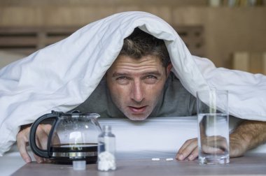 Genç yaşam tarzı ev portresi bitkin ve adam yatakta hasta ve zavallı hala sarhoş yatarken gece partide alkol içtikten sonra baş ağrısı ve akşamdan kalma acı uyanma boşa
