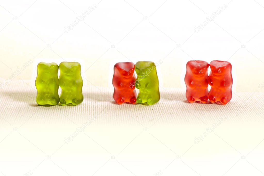 conceptual image of sweet candy gummy bears representing diversity of love with a men couple another heterosexual and lesbian women couple in gay marriage and homosexual people rights