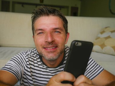 yaşam tarzı ev app dating veya sosyal medya zevk ve hücre iletişim kavramı içinde neşeli gülümseyen, cep telefonunuzda ileti Internet kullanan genç mutlu ve çekici 30'lu yaşlarda adam portresi