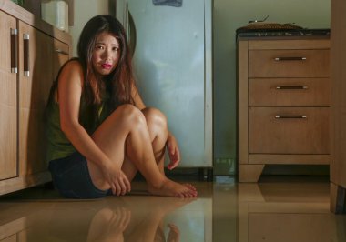 Aile içi şiddet ve cinsel taciz kurbanı kıskanç ve sarhoş alkollü koca acı ev mutfak katında çaresiz ağlayan genç korkmuş ve umutsuz Asya Japon kadın 