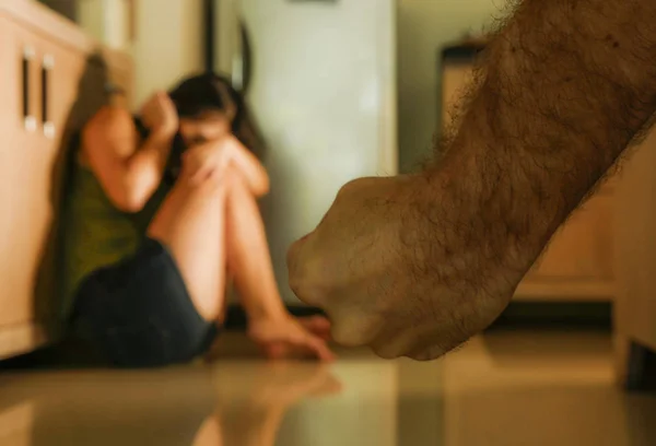 家でパニック被害者の家庭内暴力と絶望的な感じ 嫉妬深い夫による性的虐待で泣いている台所の床に座っている若い無力と恐怖の女性の劇的な肖像画 — ストック写真
