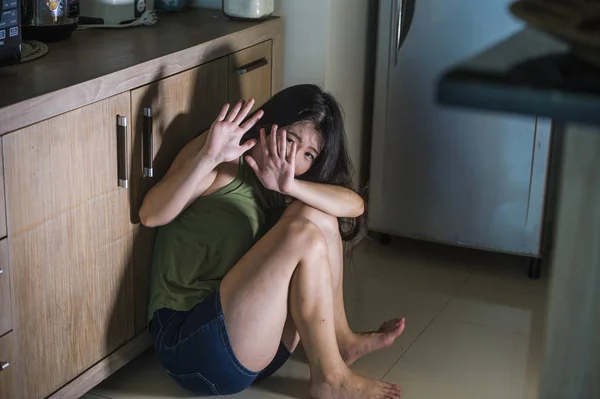 若い怖いと無力なアジア中国女性恐怖恐怖とパニックで絶望的な家庭の台所の床の泣きで酔ってアルコール中毒の夫から虐待家庭内暴力被害者の苦しみ — ストック写真