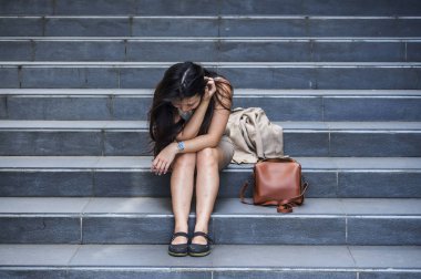 stres ve depresyon kriz mobbing kurbanı olmak acı sokak merdiven üzerinde tek başına oturmuş ağlıyor ya da işini kaybetmek ateş genç depresif ve umutsuz Asya Kore iş kadını