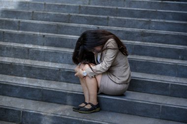 Genç depresif ve umutsuz bir işkadını yalnız mobbing kurbanı olmak ya da işini kaybetmek ateş stres ve depresyon kriz acı sokak merdiven üzerinde oturmuş ağlıyor