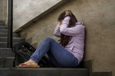 Genç üzgün ve depresyonda öğrenci veya açık havada duygu acı depresyon sorun umutsuz zorbalık sokak merdiven korkmuş ve endişeli kurbanın üzerinde oturan okulda genç kız 