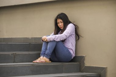 Genç üzgün ve depresyonda Asya Japon öğrenci veya okulda genç sokak merdiven bunalmış ve endişeli çaresiz hissediyor açık havada oturup depresyon sorun acı 