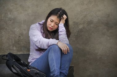 Genç üzgün ve depresyonda Asya Kore öğrenci veya okulda genç sokak merdiven bunalmış ve endişeli çaresiz hissediyor açık havada oturup depresyon sorun acı 