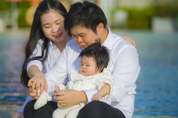 年轻开朗的妻子和丈夫夫妇与母亲和父亲抱着小女儿在亚洲韩国家庭享受节日热带度假村的爱和放松的生活方式肖像 — 图库照片