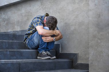 Açık havada acı anksiyete ve depresyon duygu sefil işsizlik ve kırık kalp kavramı terk ağlıyor sokak merdivenlerde oturan genç üzgün ve umutsuz adam