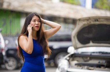 Genç umutsuz ve mutsuz Asya Çin kadında stres caddesindeki having mekanik problem üstünde hareket eden telefon yardım sigorta yardım hizmeti için arama araba motor arızası acı telli 