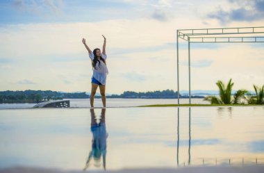 Yaz tatili genç mutlu ve çekici Asyalı Çinli kadının rahatlatıcı seyahat hedef ve Turizm kavramı sonsuzluk havuzunda eğleniyor tropikal beach Resort kaygısız