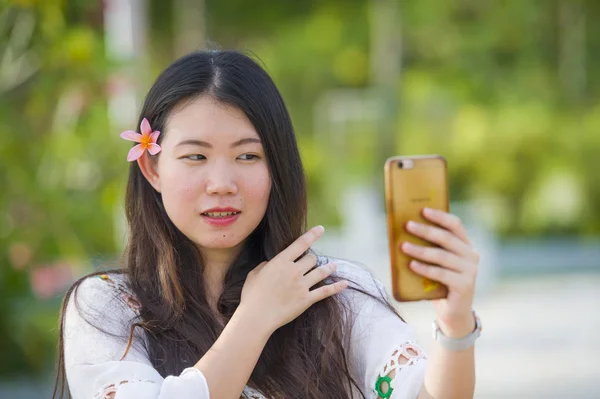 年轻快乐和美丽的亚洲韩国旅游妇女在热带度假村用手机自拍自画像照片享受暑假微笑着摆着头发花 — 图库照片