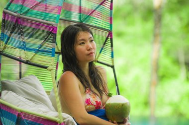 hamak içme Hindistan cevizi suyu rahatlatıcı resort havuz tropikal adada lüks tatil zevk, asılı oturan genç mutlu ve çekici Asyalı Çinli kadın