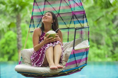 hamak içme Hindistan cevizi suyu rahatlatıcı resort havuz tropikal adada lüks tatil zevk, asılı oturan genç mutlu ve çekici Asyalı Çinli kadın
