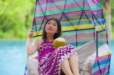 hamak içme Hindistan cevizi suyu rahatlatıcı resort havuz tropikal adada lüks tatil zevk, asılı yalan genç mutlu ve çekici Asyalı Koreli kadın