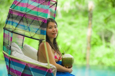 hamak içme Hindistan cevizi suyu rahatlatıcı resort havuz tropikal adada lüks tatil zevk, asılı oturan genç mutlu ve çekici Asyalı Koreli kadın
