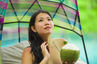 hamak içme Hindistan cevizi suyu rahatlatıcı resort havuz tropikal adada lüks tatil zevk, asılı oturan genç mutlu ve çekici Asyalı Koreli kadın