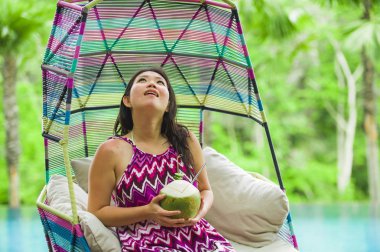 hamak içme Hindistan cevizi suyu rahatlatıcı resort havuz tropikal adada lüks tatil zevk, asılı oturan genç mutlu ve çekici Asyalı Koreli kadın