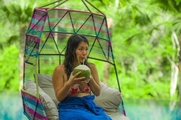 hamak içme Hindistan cevizi suyu rahatlatıcı resort havuz tropikal adada lüks tatil zevk, asılı oturan genç mutlu ve çekici Asyalı Çinli kadın