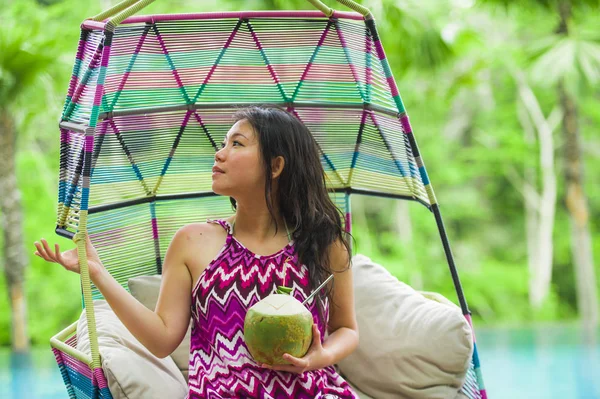 hamak içme Hindistan cevizi suyu rahatlatıcı resort havuz tropikal adada lüks tatil zevk, asılı oturan genç mutlu ve çekici Asyalı Çinli kadın