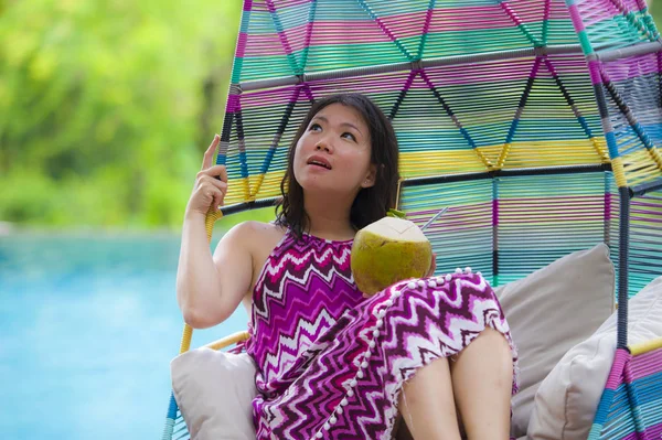 hamak içme Hindistan cevizi suyu rahatlatıcı resort havuz tropikal adada lüks tatil zevk, asılı yalan genç mutlu ve çekici Asyalı Çinli kadın