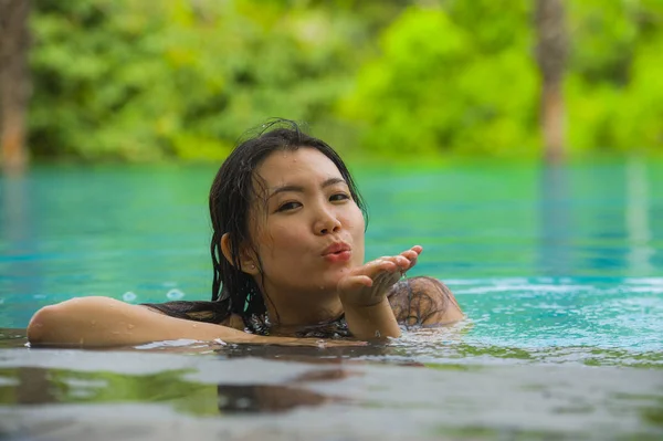 魅力的で美しいアジア中国女性水泳熱帯のビーチ リゾートで満足して夏を楽しんでジャングル インフィニティ プールでの楽園の島での休暇旅行先リラックス — ストック写真