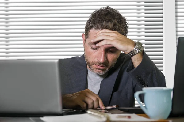 young attractive upset and stressed businessman working overwhelmed suffering stress at office computer desk in corporate business job problem isolated on white background