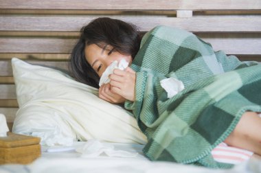 Genç tatlı Asya kız pijama soğuk algınlığı ve grip tıbbi sağlık ve grip virüs hastalık kavramı içinde acı yatakta ateşli yalan battaniye ile kaplı Korece hasta