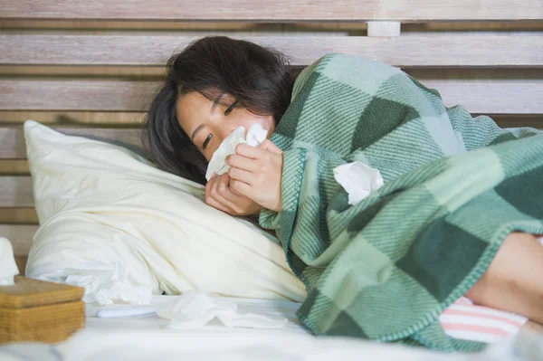 Genç tatlı Asya kız pijama soğuk algınlığı ve grip tıbbi sağlık ve grip virüs hastalık kavramı içinde acı yatakta ateşli yalan battaniye ile kaplı Korece hasta