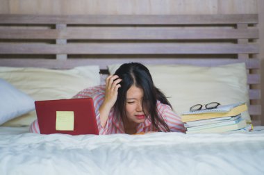 duygu boğulmuş ve stresli stres içinde dizüstü bilgisayar ile sınavı eğitim hazırlama ve ev yatak, çok çalışan genç sinirli ve yorgun Asya Kore Üniversitesi öğrenci kız