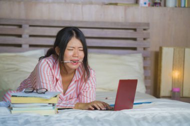 duygu boğulmuş ve stresli stres içinde dizüstü bilgisayar ile sınavı eğitim hazırlama ve ev yatak, çok çalışan genç sinirli ve yorgun Asya Japon üniversite öğrenci kız