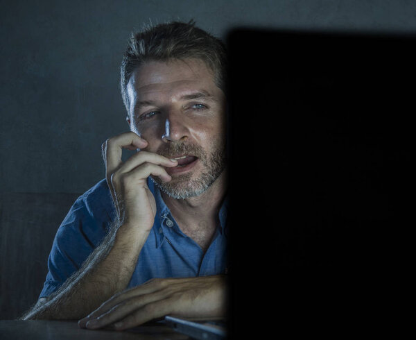 молодой возбужденный и возбужденный секс-наркоман мужчина смотрит порно мобильный онлайн в ноутбуке компьютер светлая ночь на домашнем столе в порнографии наркомании и интернет-порнографического содержания концепции
