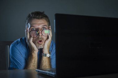 garip şok ve dizüstü bilgisayar içinde karanlık seyir geç gece komik ve saçma şok ve güvensizlik yüz ifadesi üzerinde inek bardaklarda geek adam şaşırttı 