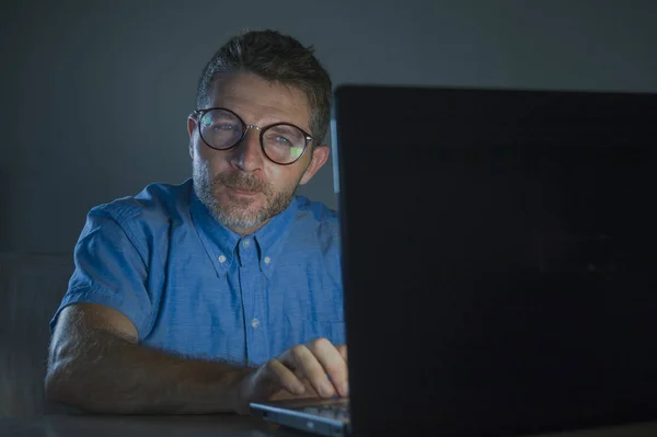 大きなメガネとシャツ作業深夜暗い見て愚かな 技術とオタクのライフ スタイルのコンセプトのばかばかしいラップトップ コンピューターでインターネットを使用して満足している奇妙なこざっぱりとした清楚オタク男 — ストック写真
