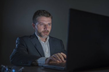 ticaret forex piyasası veya koyu arka plan üzerinde izole verileri analiz mali iş dizüstü bilgisayar kullanan gece geç saatlerde çalışan genç çekici ve adanmış işkolik girişimci adam