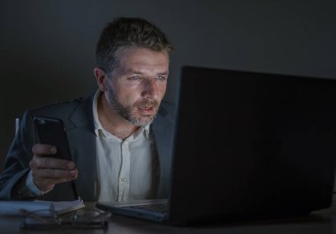 ticaret forex piyasası veya koyu arka plan üzerinde izole verileri analiz mali iş dizüstü bilgisayar kullanan gece geç saatlerde çalışan genç çekici ve adanmış işkolik girişimci adam