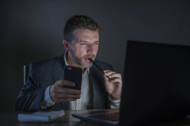 ticaret forex piyasası veya koyu arka plan üzerinde izole verileri analiz mali iş dizüstü bilgisayar kullanan gece geç saatlerde çalışan genç çekici ve adanmış işkolik girişimci adam