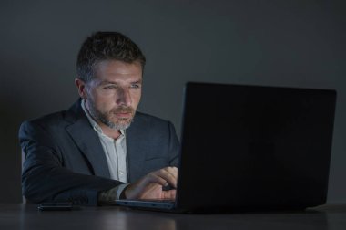 ticaret forex piyasası veya koyu arka plan üzerinde izole verileri analiz mali iş dizüstü bilgisayar kullanan gece geç saatlerde çalışan genç çekici ve adanmış işkolik girişimci adam