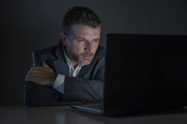 ticaret forex piyasası veya koyu arka plan üzerinde izole verileri analiz mali iş dizüstü bilgisayar kullanan gece geç saatlerde çalışan genç çekici ve adanmış işkolik girişimci adam