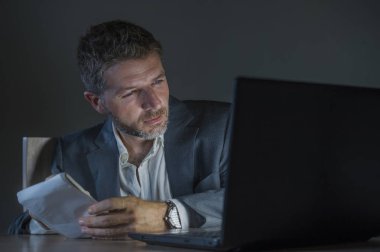 ticaret forex piyasası veya koyu arka plan üzerinde izole verileri analiz mali iş dizüstü bilgisayar kullanan gece geç saatlerde çalışan genç çekici ve adanmış işkolik girişimci adam